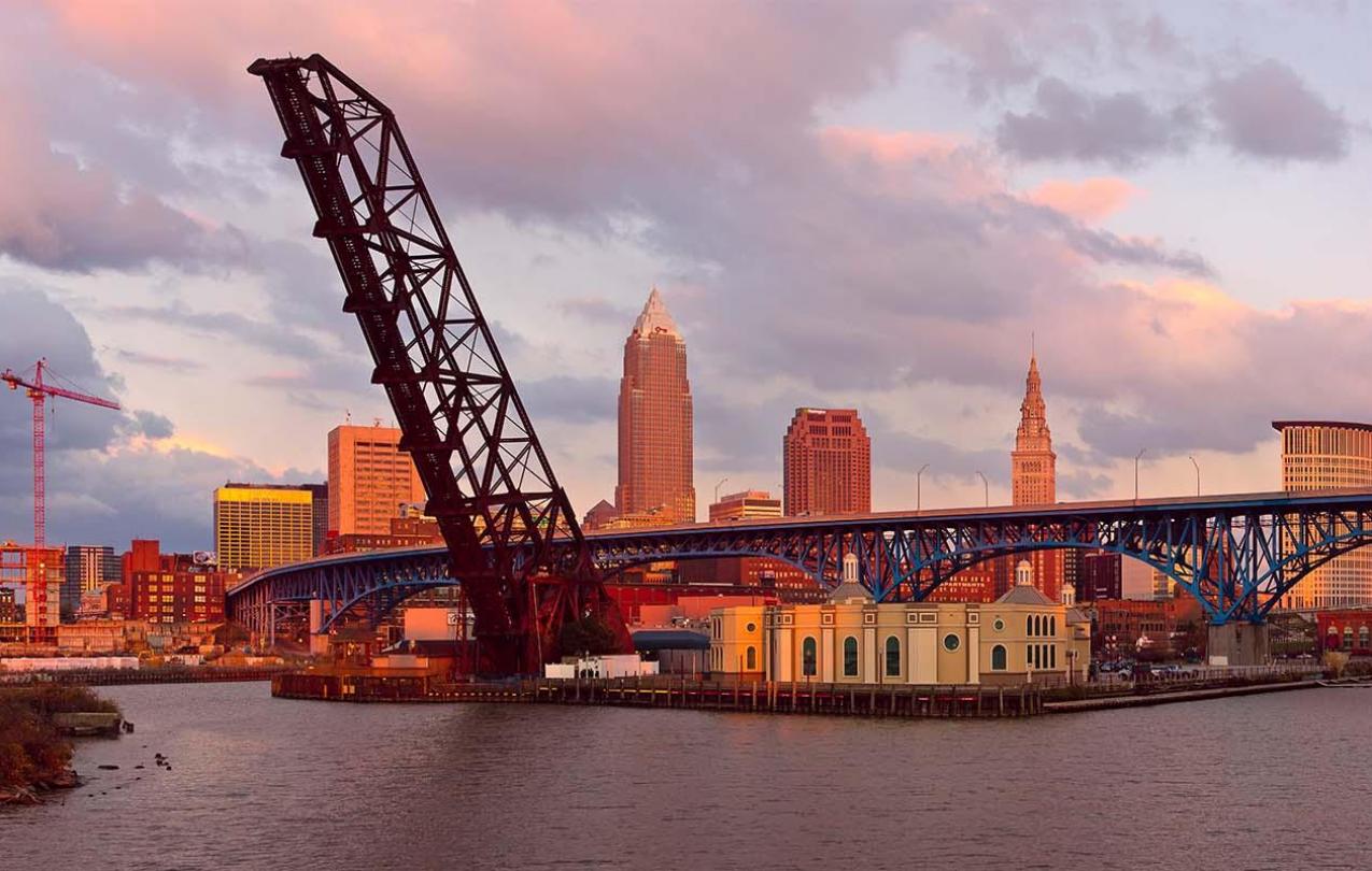 Photo of crane and bridge with a skyline in the background.